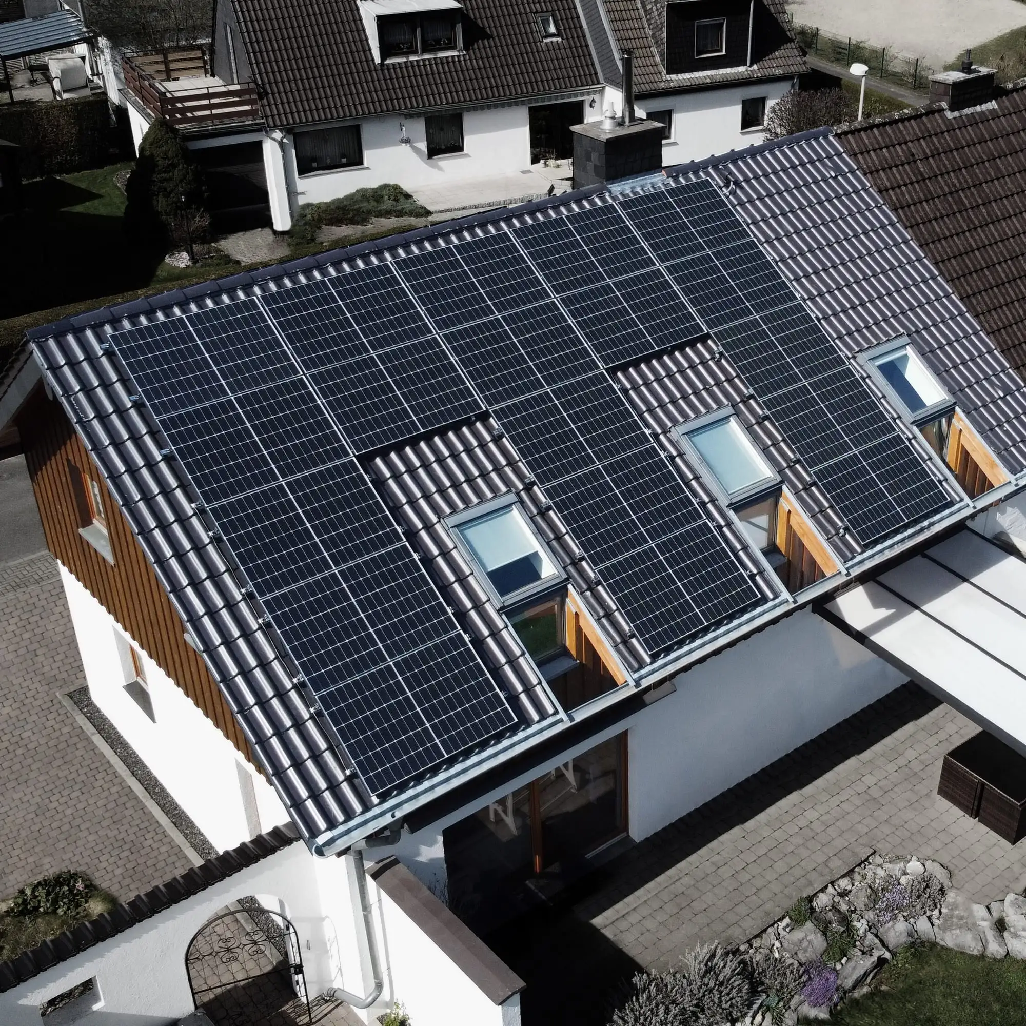 Einfamilienhaus mit PV-Anlage auf dem Dach, Blick von der Gartenseite