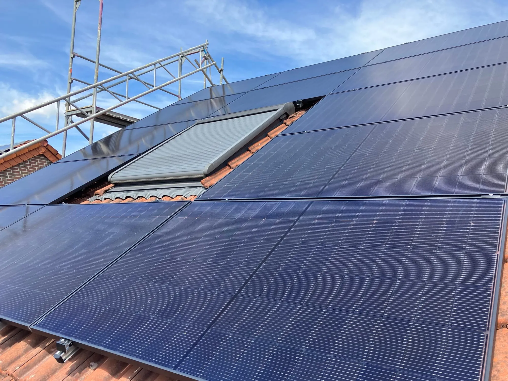 All-Black-PV-Module auf einem Steildach mit roten Ziegeln